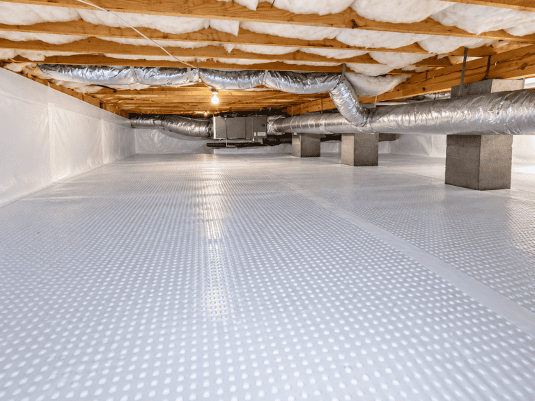 A crawl space with a dimpled white vapor barrier for basement waterproofing on the ground, concrete support pillars, and silver HVAC ductwork beneath exposed floor joists.